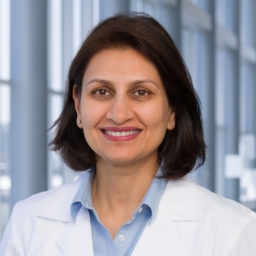 Dr. Namirah Jamshed wearing a light blue shirt and a white lab coat standing in the Clements University Hospital
