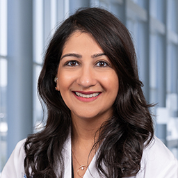 Dr. Poonam Puri wearing a white lab coat standing in the Clements University Hospital lobby