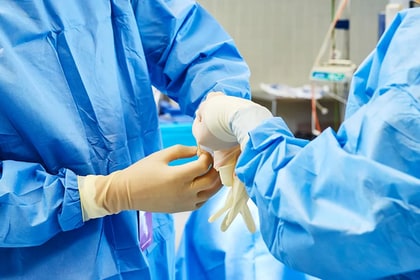 two surgeons putting on gloves