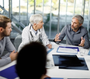 Medical professionals sitting in a meeting, talking